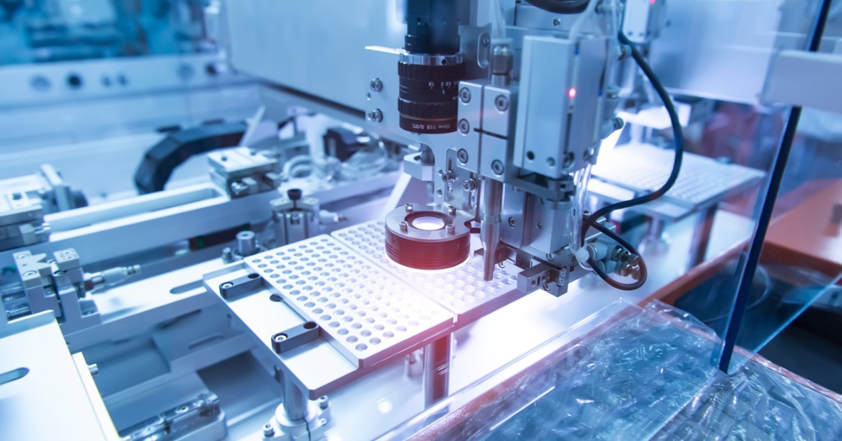 An automated inspection line uses machine vision cameras and red lighting to examine parts on a production system.
